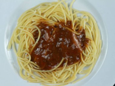 Domates soslu spagettiyi beyaz tabakta yakın.