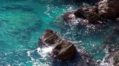 Güzel deniz dalgalarının ve kayaların üzerindeki köpüklerin havadan görünüşü suyun üst görüntüsü, okyanusun havadan görünüşü. Doğa ve tatil kavramı