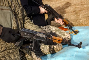 Otomatik Kalaşnikof tüfeği tutan adam.