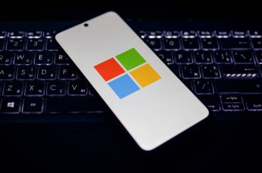 Kherson Reg, Ukrayna 19 Eylül 2024 'te Microsoft logo ikonunun yakın plan fotoğrafı aydınlatılmış dizüstü bilgisayarın klavyesinde duran akıllı telefon ekranında sergilendi