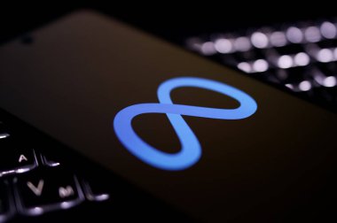 Kherson Reg, Ukrayna 19 Eylül 2024 'te yakın plan Meta logosunun aydınlatılmış dizüstü bilgisayarın klavyesinde duran akıllı telefon ekranında çekilmiş fotoğrafı