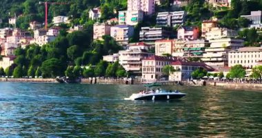 Şehrin güzel zeminine karşı Como Gölü 'nü geçen bir motorlu tekne.