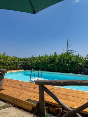 Tahta güverteli yüzme havuzu ve mavi gökyüzü yaz tatili arka planı