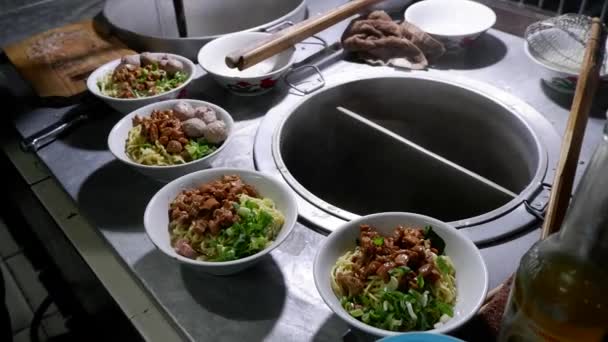 인도네시아의 길거리 음식인 미에아 야암을 요리하는 과정에서 요리사는 손님들에게 그릇을 — 비디오