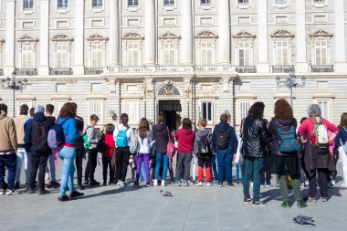 Madrid 'deki Kraliyet Sarayı' nın dışındaki nöbetçilerin değişimini izleyen büyük bir grup insan ve turist..