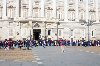 Madrid 'deki Kraliyet Sarayı' nın dışındaki nöbetçilerin değişimini izleyen büyük bir grup insan ve turist..
