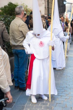 İspanya 'nın başkenti Madrid' deki Palm Sunday geçit töreninde beyaz ceketlerini düzelten Nazarenos de Nuestro Padre de Jesus del Amor 'dan bir öğrenci birliği üyesi..