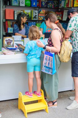 2023 Madrid Kitap Fuarı 'nın 82. baskısı sırasında çocuk kitaplarına bakan bir anne ve oğul..