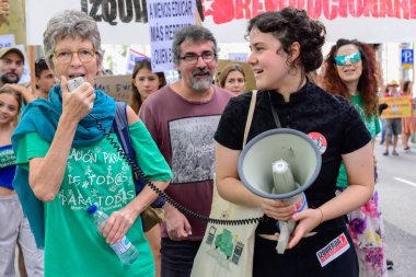 İspanya 'nın Madrid kentindeki Marea Verde gösterisinde, özel okullara destek olmak için devlet eğitim parasının yağmalanmasına karşı megafin kullanan bir protestocu..
