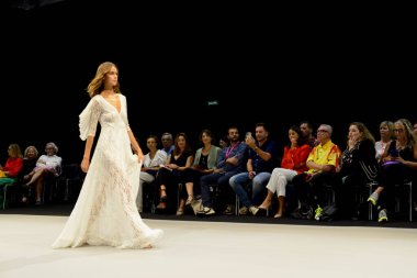 IFEMA Madrid 'deki Momad 2023 fuarında Adlib moda koleksiyonu sırasında beyaz uzun bir elbise giyen bir manken..