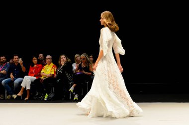 IFEMA Madrid 'deki Momad 2023 fuarında Adlib moda koleksiyonu sırasında beyaz uzun bir elbise giyen bir manken..