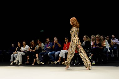 Momad 2023 'teki IFEMA Madrid ticaret fuarında Adlib moda koleksiyonunda podyumda çok renkli pantolon giyen bir manken..