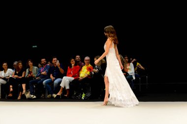 IFEMA Madrid 'deki Momad 2023 fuarında Adlib moda koleksiyonu sırasında beyaz uzun bir elbise giyen bir manken..