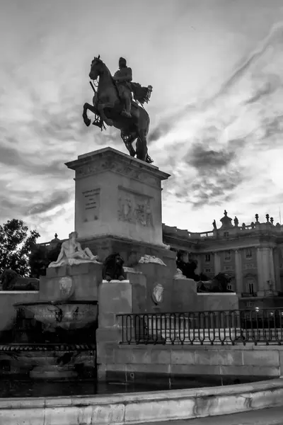 Felipe IV anıtının silueti Plaza de Oriente 'de koyu mavi gökyüzü ve kırmızı bulutlarla, Madrid İspanya