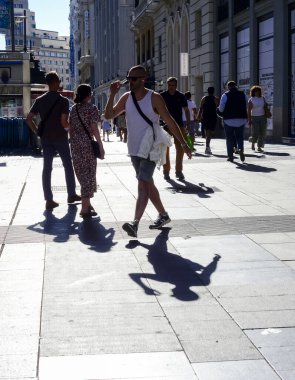 Sıcak bir yaz günü, Madrid İspanya 'da akşamüstü saat 6' da Gran Via 'da yürüyen insanların siluet görüntüsü. Madrid İspanya 4 Temmuz 2024 