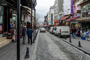 İSTANBUL, TURKEY - 23 Mart 2023: İstanbul 'da küçük mağazalar, insanlar ve arabalar ile dar bir yerleşim yeri.