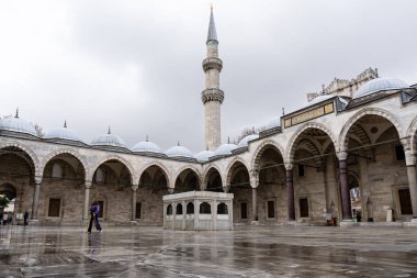 İSTANBUL, TURKEY - 23 Mart 2023: Minare manzaralı Süleyman Camii avlusunda turistler