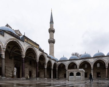 İSTANBUL, TURKEY - 23 Mart 2023: Minare manzaralı Süleyman Camii avlusunda turistler