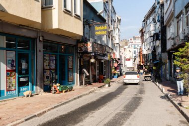 İSTANBUL, TURKEY - 25 Mart 2023: Restoranları ve konut binaları olan eski şehir caddesi