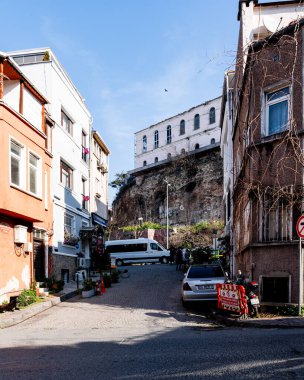 İSTANBUL, TURKEY - 25 Mart 2023: Arabaları ve konut binaları olan eski şehir caddesi