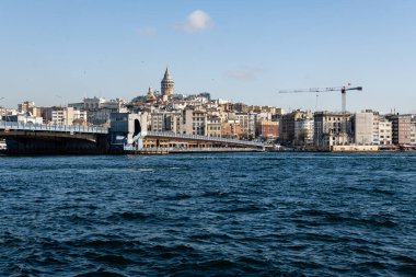 ISTANBUL, TURKEY - 24 Mart 2023: Arka plandaki Altın Boynuz ve Galata kulesi manzarası ve tarihi binalar üzerinde şehir manzarası