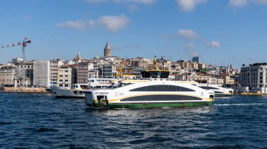 ISTANBUL, TURKEY - 24 Mart 2023: Arka planda Galata kulesi ve Golden Horn boğazında modern feribot ile İstanbul şehir manzarası