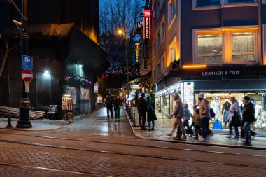 İSTANBUL, TURKEY - 26 Mart 2023: tramvaylı şehir caddesi ve gece vakti inşaat ve pazarlama yapan insanlar