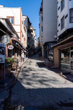 İSTANBUL, TURKEY - 27 Mart 2023: Eski evleri, dükkanları ve restoranları olan dar ve güzel bir cadde