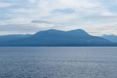 Gürcistan Boğazı 'nda bulutlar mavi gökyüzü su manzarası dağları ufukta Britanya Kolumbiyası Kanada