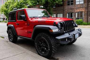 TORONTO, CANADA - 10 Haziran 2024: Güzel kırmızı Amerikan off-road Jeep Wrangler caddeye park etmiş