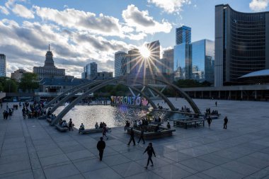 TORONTO, CANADA - Haziran 09, 2024: Nathan Phillips Meydanı 'nda ışıklandırılmış Toronto tabelası ve belediye binası ile çeşme
