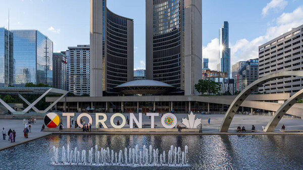 ТОРОНТО, КАНАДА - 09 июня 2024 года: фонтан на площади Натана Филипса с подсветкой Торонто и ратушей