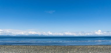 Malcolm Adası kıyılarından panorama manzarası. Okyanusun güzel suyu. Mavi gökyüzünde bulutlar.