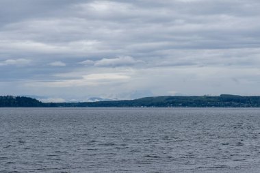 Gürcistan Boğazı 'nda bulutlar mavi gökyüzü su manzarası dağları ufukta Britanya Kolumbiyası Kanada