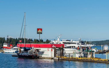 NANAIMO, CANADA - 02 Temmuz 2024: Nanaimo Limanı Havalimanı İskelesi, güneşli yaz günlerinde tekne ve feribot ve turistler