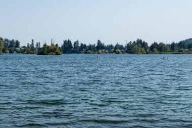 LANGFORD, CANADA - 10 Ağustos 2024 Floransa Gölü ve yeşil ağaçlı mavi gökyüzü