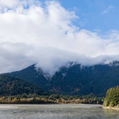 Fraser nehri ve dağları ve bulutları olan ormanın güzel sonbahar manzarası. Manzaralı kırsal alan. Sonbahar doğası