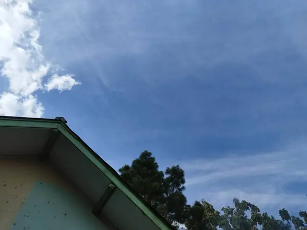 corner of the roof of the house with the sky in the background