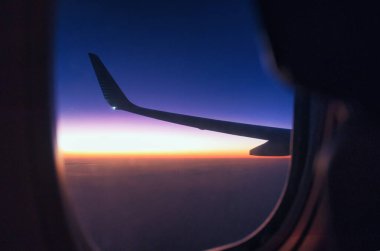 bir uçağın yolcu koltuğundan gün doğumu