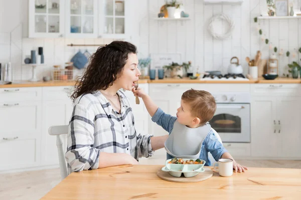 Adorable Toddler Boy Feeding His Young Mother While She Tries — Foto Stock