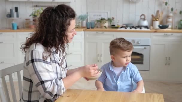 可爱的幼儿男孩拒绝吃他妈妈给他的食物 一位年轻的母亲担心 她的儿子不想吃发酵过的奶制品 于是试图说服他尝一些 — 图库视频影像