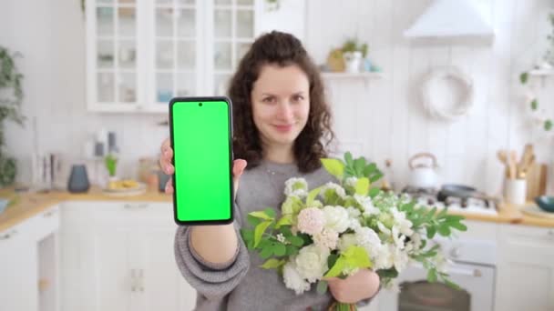 Молода Щаслива Біла Жінка Квітами Руках Тримає Смартфон Зеленим Екраном — стокове відео