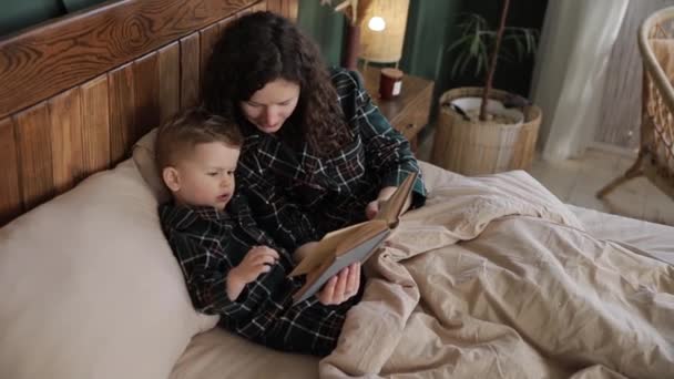 Молода Жінка Перед Сном Читає Книжку Казками Своєму Синочку Дитина — стокове відео