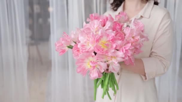 难以辨认的高加索女人手里拿着一丛丛美丽的粉色郁金香 非常近 初春的花束在手中 植物学业务或花卉递送的概念 浅色的Dof — 图库视频影像