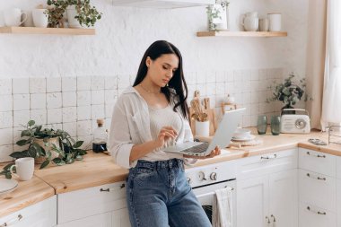 Kendine güvenen bir kadın ressamın portresi ya da mutfakta dizüstü bilgisayar başında çalışan bir öğrenci ev işleri ya da yemek yapmak arasında mola veriyor. Eğitim, iş ve ev hayatını dengeleme kavramı.