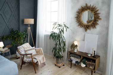 Kalıplı koltuğu, rahat battaniyesi ve püsküllü yastığı olan rahat bir yer. Ahşap lamba ve yeşillik huzur ortamını güçlendirir. Güneş ışığı aynası ve beyaz perdeler görüntüyü tamamlıyor..