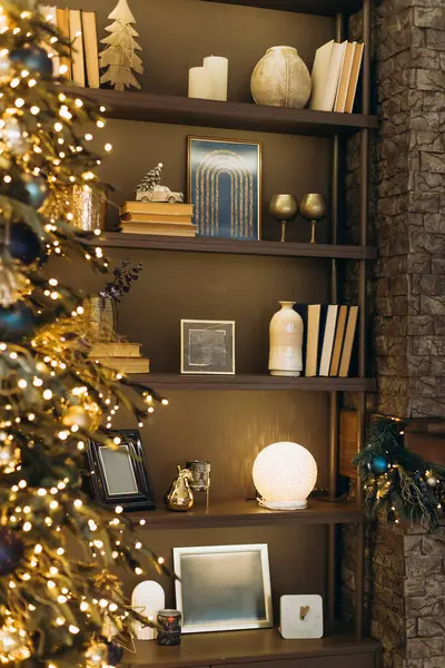 Kitaplarla, mumlarla, küçük Noel ağacıyla, çerçeveli resimlerle, süslemelerle, sıcak Noel ışıklarıyla, şenlikli tatil atmosferiyle, iç dekorasyonla, sığ DOF ile dolu rahat bir kitaplık..