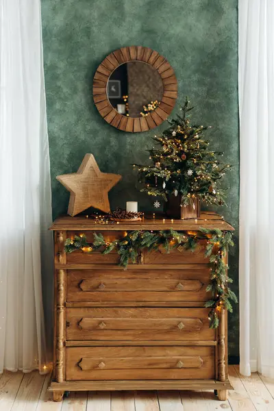 Noel için dekore edilmiş eski ahşap çekmeceler. Dekoratif bir yıldız ve içinde Noel ağacı çelengi olan çekmecelerin üzerinde çelenk ışıkları olan küçük yeşil bir Noel ağacı. Noel arşivi.