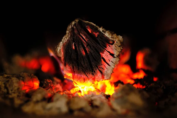 Burning logs and ashes inside a wood-burning fireplace