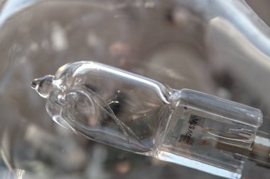 Yanmış bir akkor ampulün, cam bir lambanın içinde kırık bir kurtçuk lifiyle yakın plan görüntüsü. 230V ve 57W güç tüketimi için.. 
